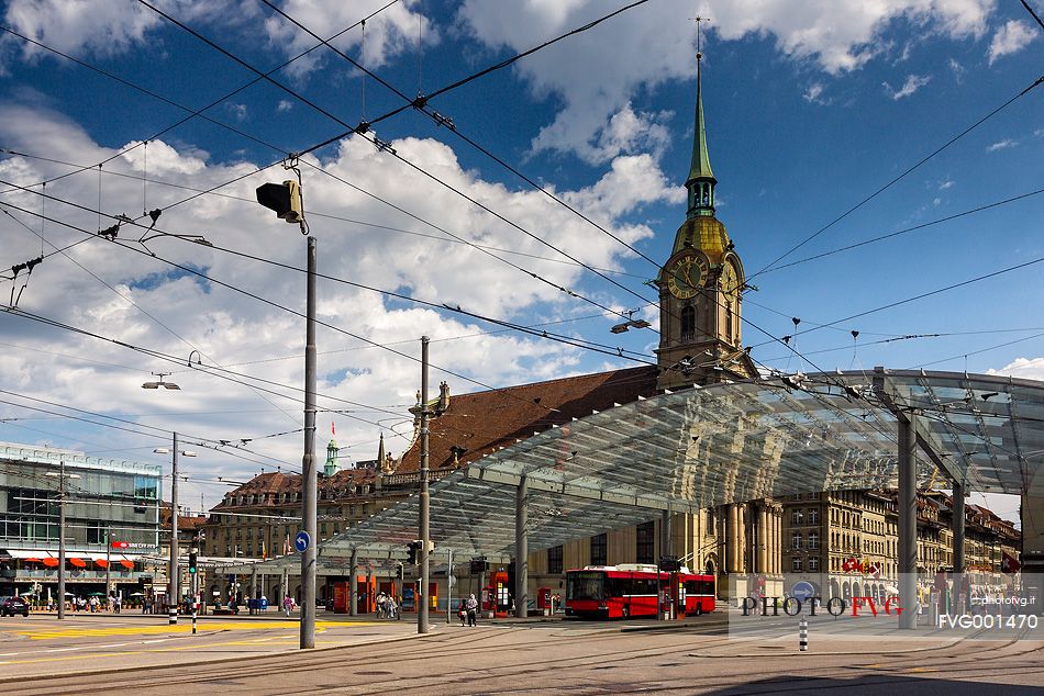 The modern covered tram and train station and in the background Holy Spirit Church or Heiliggeistkirche, Berne, Switzerland, Europe 