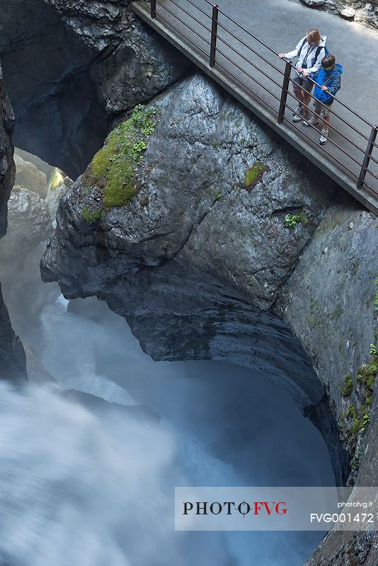 Tourists at the Trummelbach waterfalls formed by melting waters of Jungfrau glacier, Lauterbrunnen valley, Switzerland, Europe