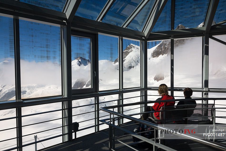 Tourists inside the Sphinx Observatory on top of the Jungfraujoch admiring the Aletsch glacier, the largest in Europe, Bernese alps, Switzerland, Europe