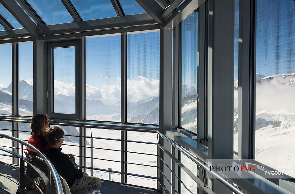 Tourists inside the Sphinx Observatory on top of the Jungfraujoch admiring the Aletsch glacier, the largest in Europe, Bernese alps, Switzerland, Europe