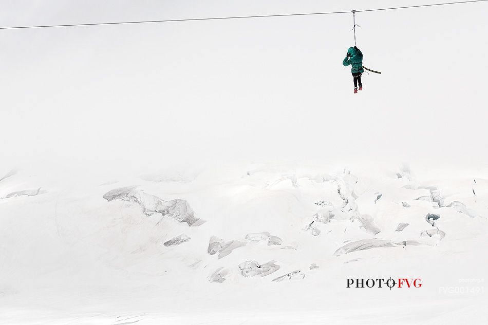 Fun on Aletsch glacier, floating on the steel cable over crevasses, Jungfraujoch, Berner Oberland, Switzerland, Europe