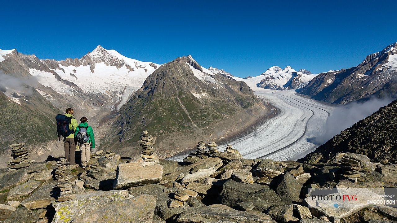 Mother and son at the Eggishorn mountain admiring the Aletsch glacier and Jungfrau mountains, Valais, Switzerland, Europe