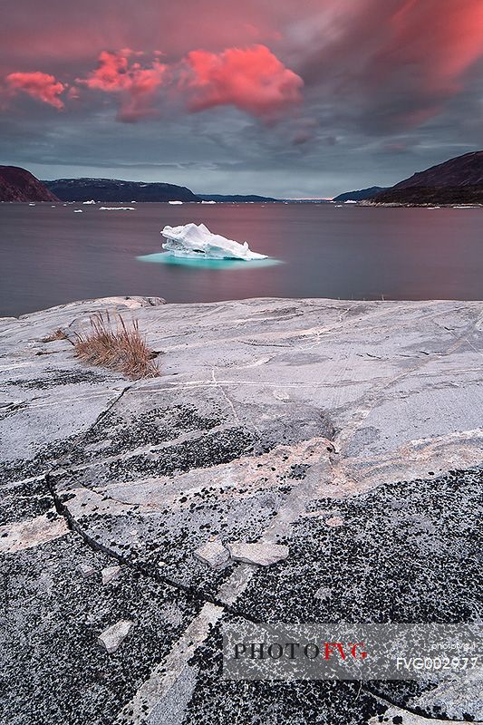 Pink clouds above iceberg in the sea in front  of Ataa a small village of
fishermen and seal hunters which was abandoned in the 50s