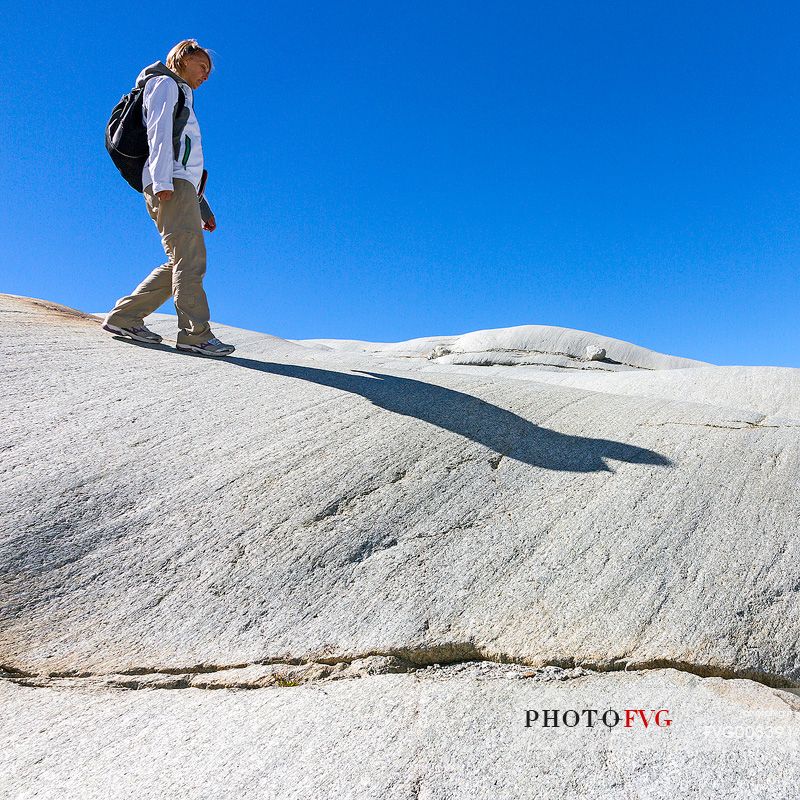 Tourist walks in the rocks of the Rhone glacier, Furka pass, Valais, Switzerland, Europe