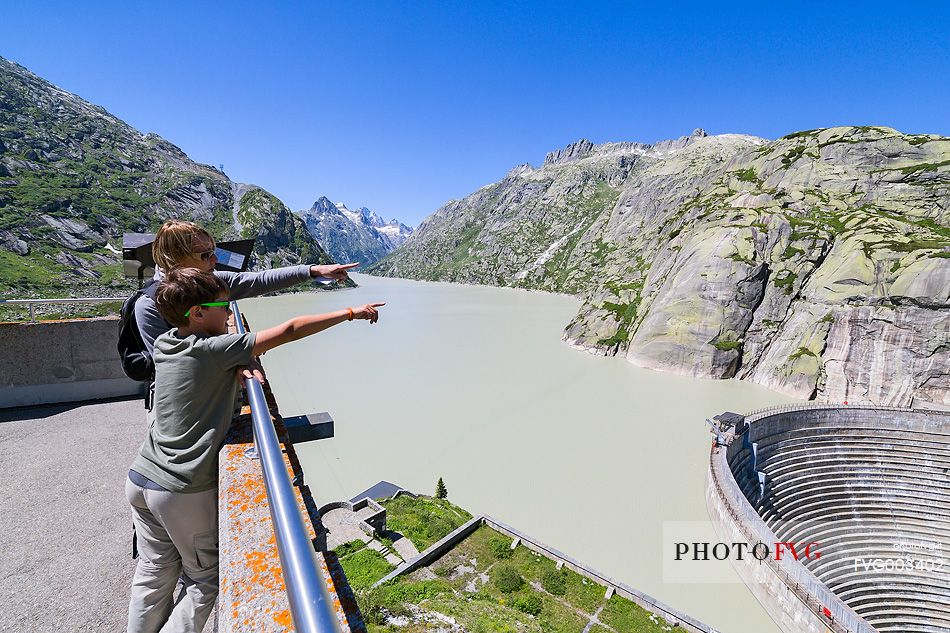 Tourists looking the Spitallamm dam and Grimselsee or Grisel lake, Grimsel pass, Bernese alps, Switzerland, Europe