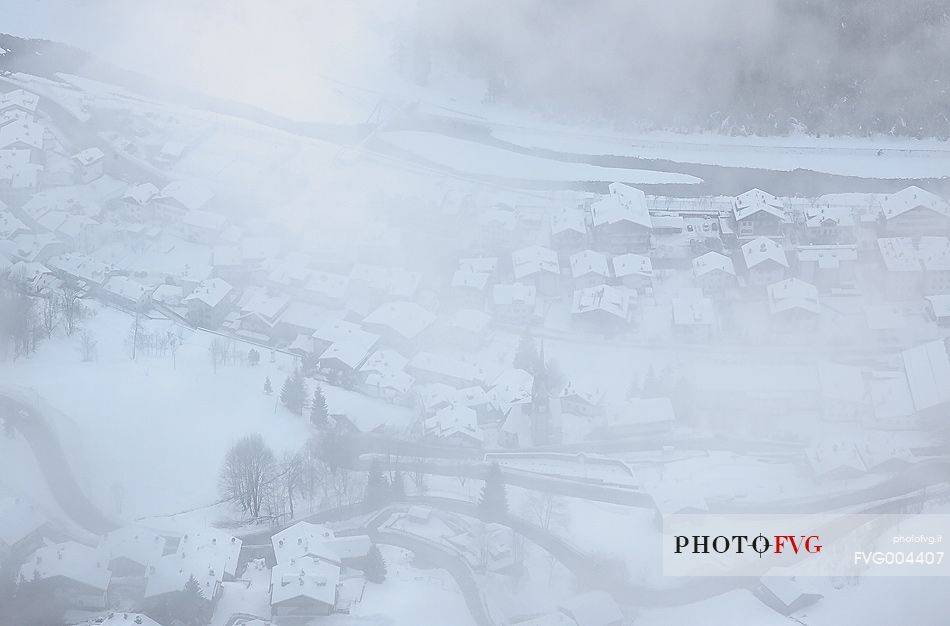 Winter in the small village of Caprile and the Cordevole river 