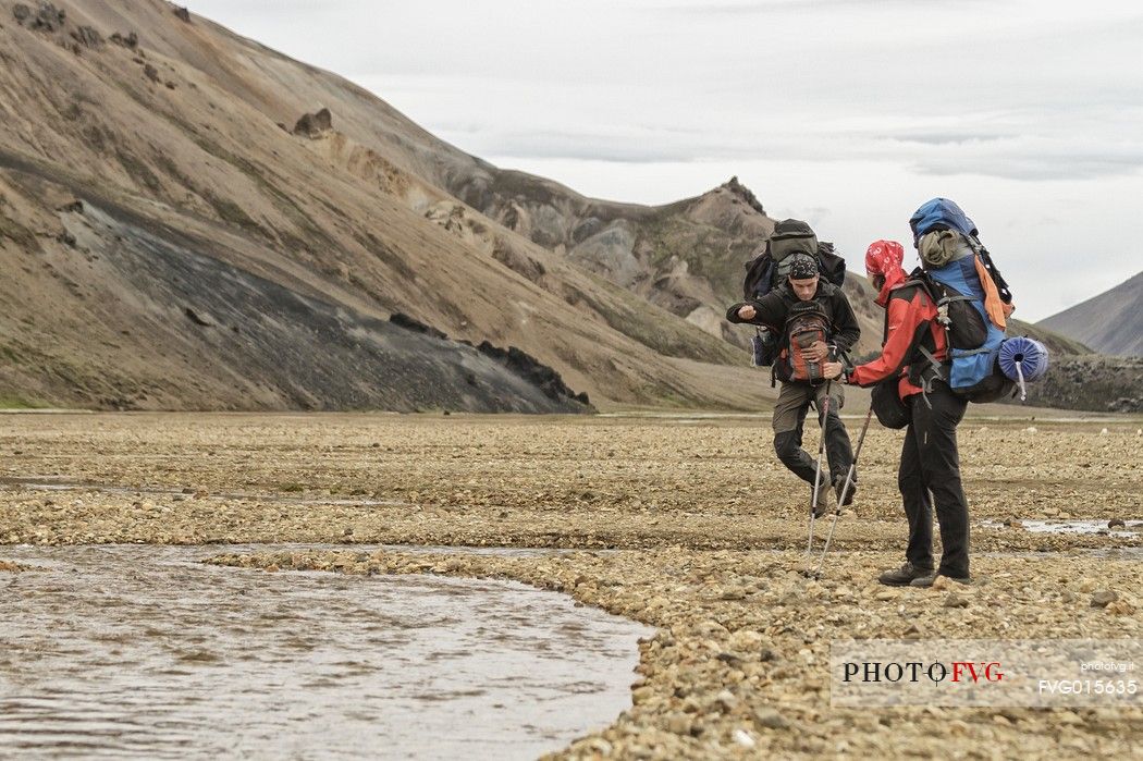 Young people hiking in multicoloured rhyolite mountain area of Landmannalaugar