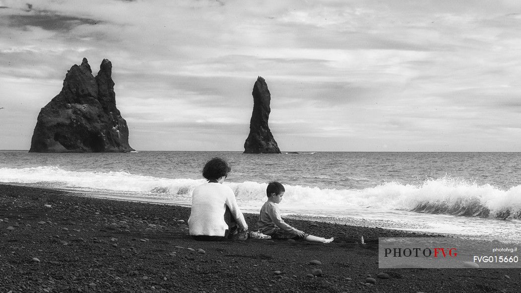 A family, mother and child, relaxing in the Vik beach