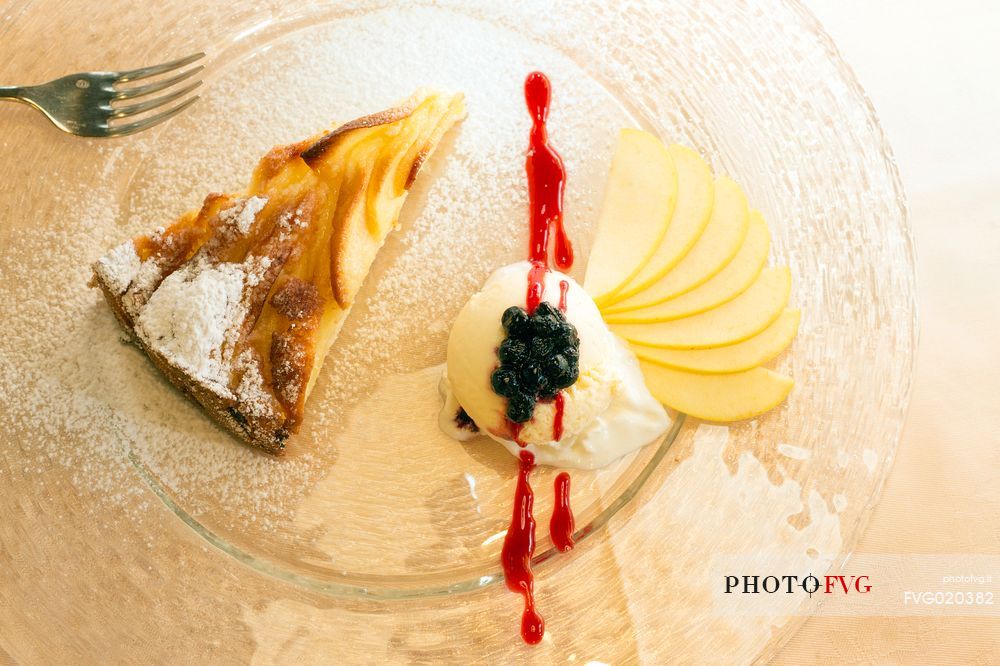 Apple pie with vanilla ice cream, blueberries and raspberry sauce, restaurant alla Pace of Sauris
