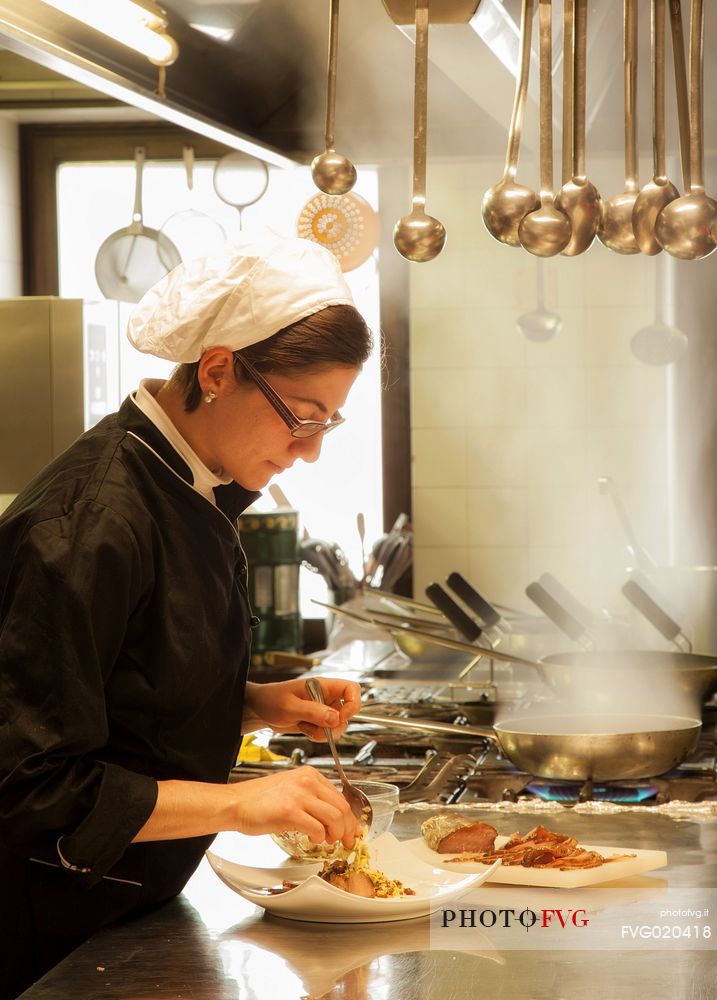 Chef working in the kitchen of Morgenleit restaurant, Sauris