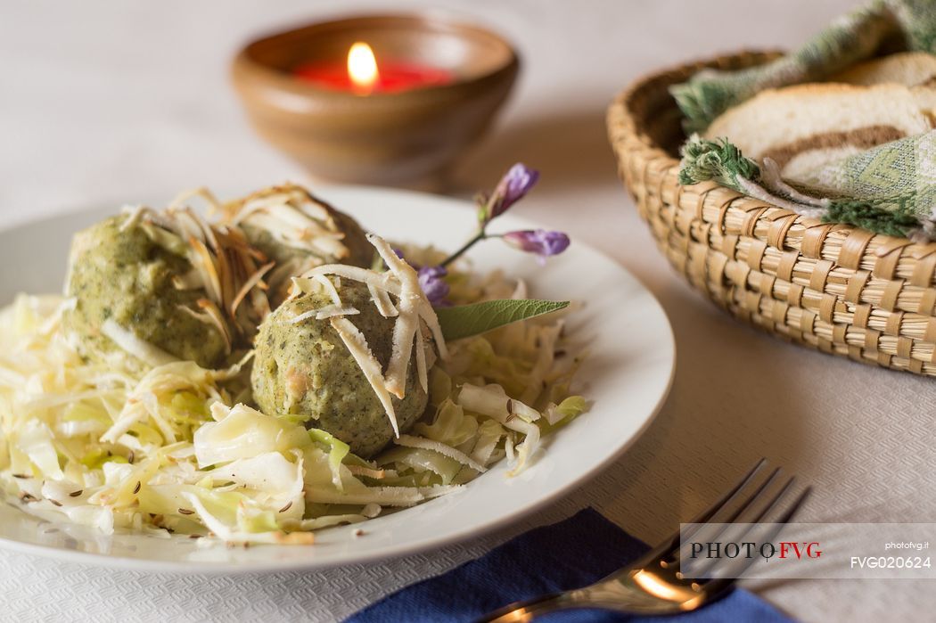 Typical platter of dumplings and sauerkraut with parmesan shavingsin Malga Rinfreddo, Comelico, Dolomites, Italy