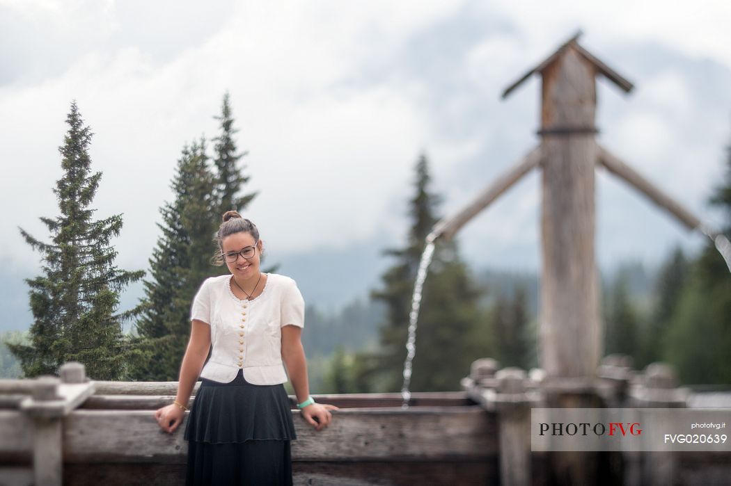 Smiling girl with a traditional dress at Rinfreddo hut, Comelico, dolomites, Italy