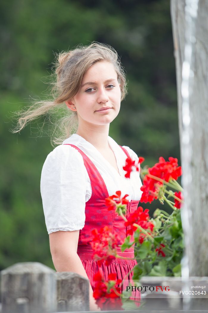 Smiling girl wearing traditional costume at Rinfreddo hut, Comelico, dolomites, Italy