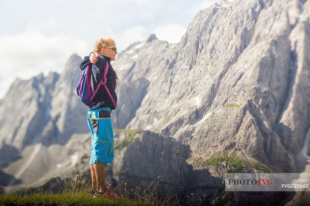 A young hiker looks the Popera group in the Sesto Dolomites from Forcella Pian della Biscia, Comelico, Italy