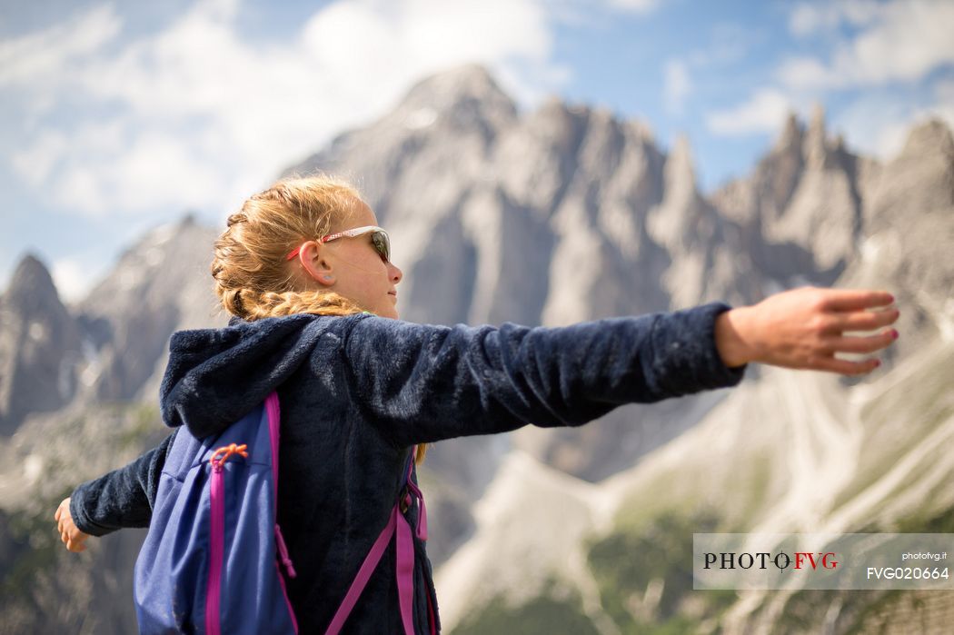 A young hiker looks the Popera group in the Sesto Dolomites from Forcella Pian della Biscia, Cadore, Italy