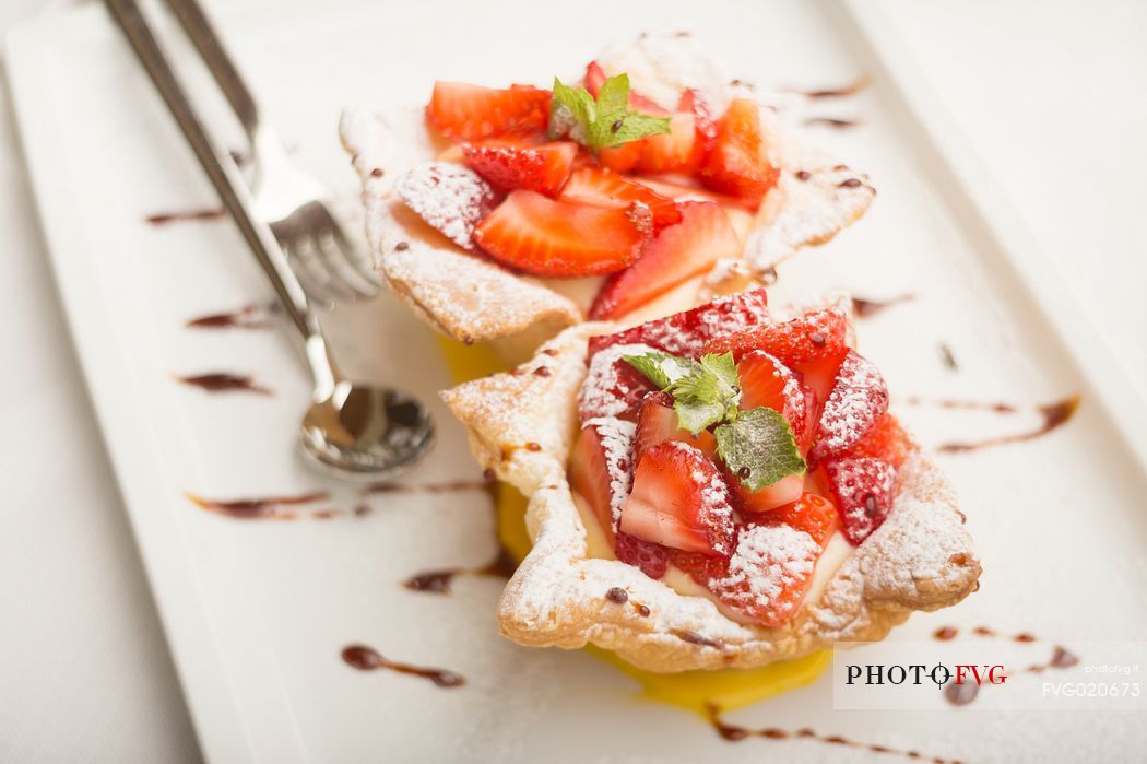 Short pastry basket with strawberries and custard at restaurant Skay of Comelico Superiore, Cadore, Italy