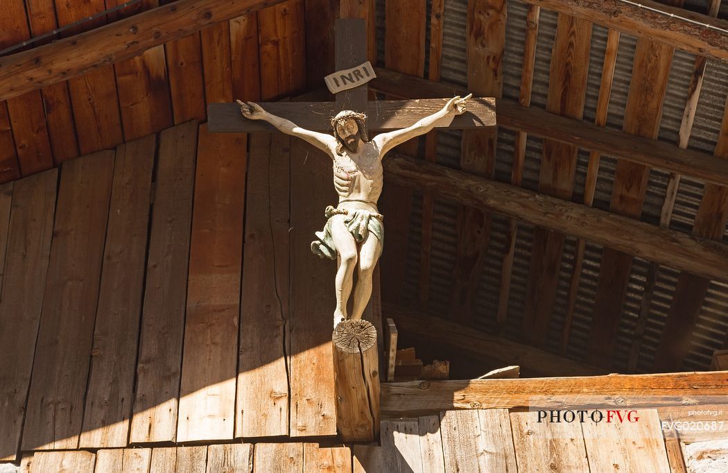 Crucifix hanging on a barn in Dosoledo, Comelico Superiore, dolomites, Italy