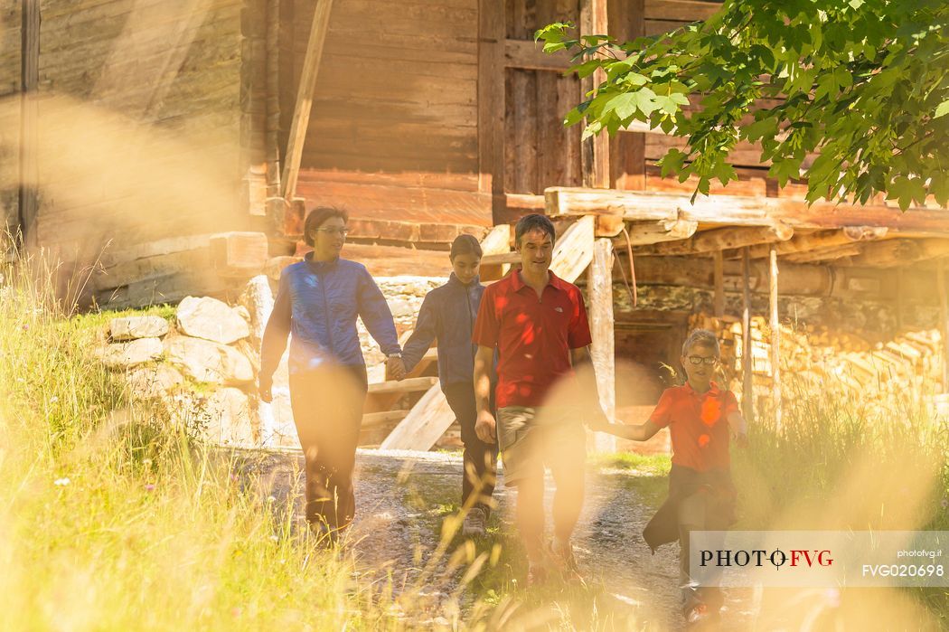 Family walking between the huts of Val Visdende, Comelico, Italy
