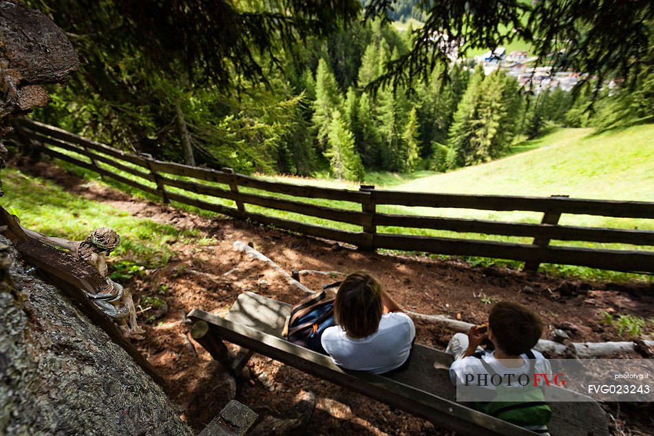 Walkers are resting along the path of larches in Badia Valley, south tyrol, dolomites, Italy