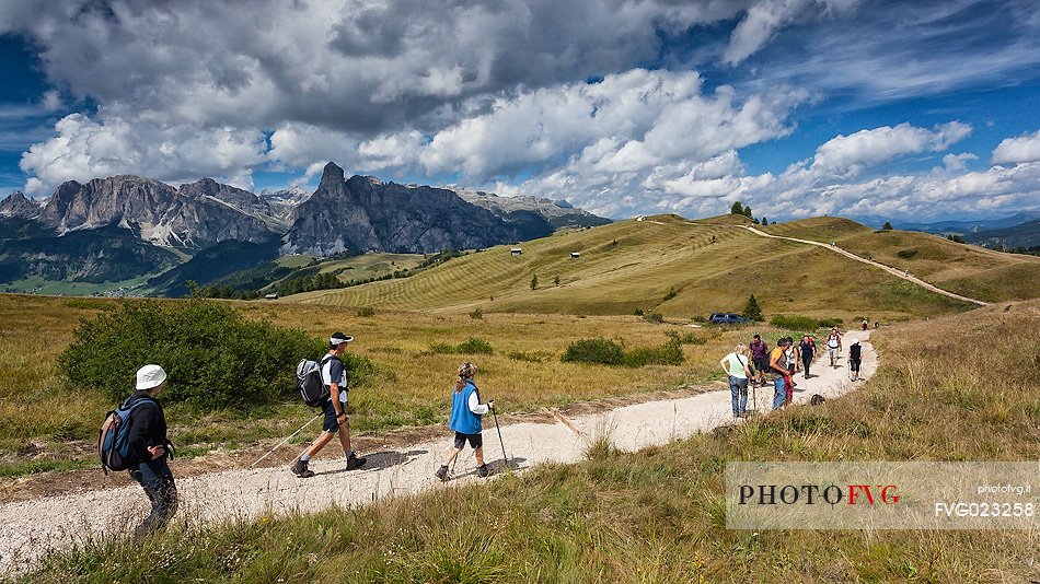 Hikers along the path of Pralongi meadows, Badia Valley, South Tyrol, Dolomites, Italy