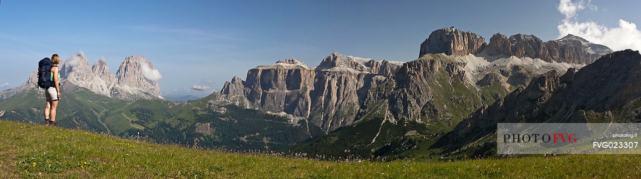 Hiker is admiring Sella and Sassolungo mountain from Belvedere hut, Canazei, Fassa Valley, Dolomites, Italy
 