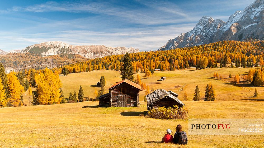 Mother and child admiring the Dolomite's autumn landscape, Prati dell'Armentara, Sasso della Croce mountain group in background, Badia Valley, Italy, Fanes Senes Braies Natural Park 