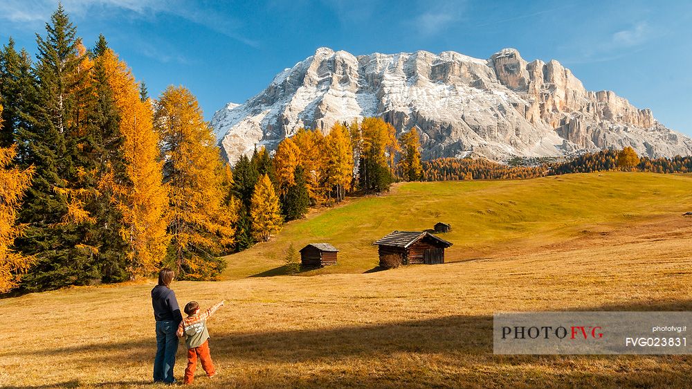 Mother and child admiring the Dolomite's autumn landscape, Prati dell'Armentara, Sasso della Croce mountain group in background, Badia Valley, Italy, Fanes Senes Braies Natural Park 