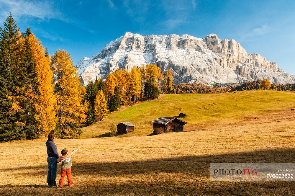 Mother and child admiring the Dolomite's autumn landscape, Prati dell'Armentara, Sasso della Croce mountain group in background, Badia Valley, Italy, Fanes Senes Braies Natural Park 