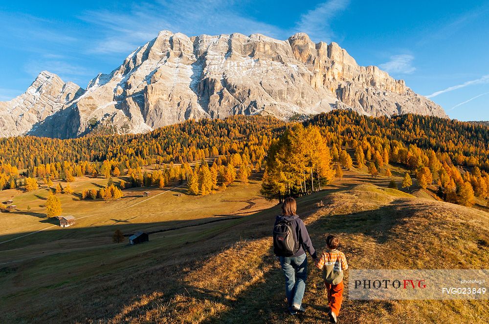 Mother and child admiring the Dolomite's autumn landscape, Prati dell'Armentara, Sasso della Croce mountain group in background, Badia Valley, Italy, Fanes Senes Braies Natural Park 