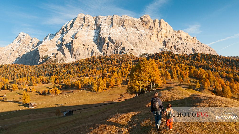 Mother and child admiring the Dolomite's autumn landscape, Prati dell'Armentara, Sasso della Croce mountain group in background, Badia Valley, Italy, Fanes Senes Braies Natural Park 