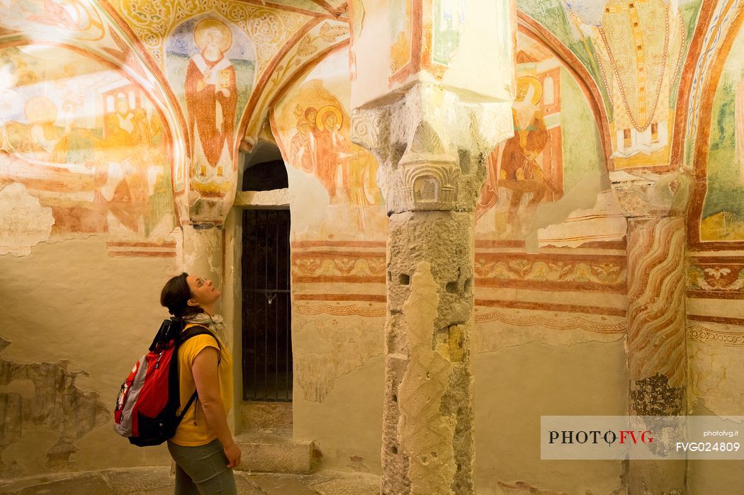 Tourist visiting the crypt and the magnificent frescoes of the Basilica of Aquileia, Italy