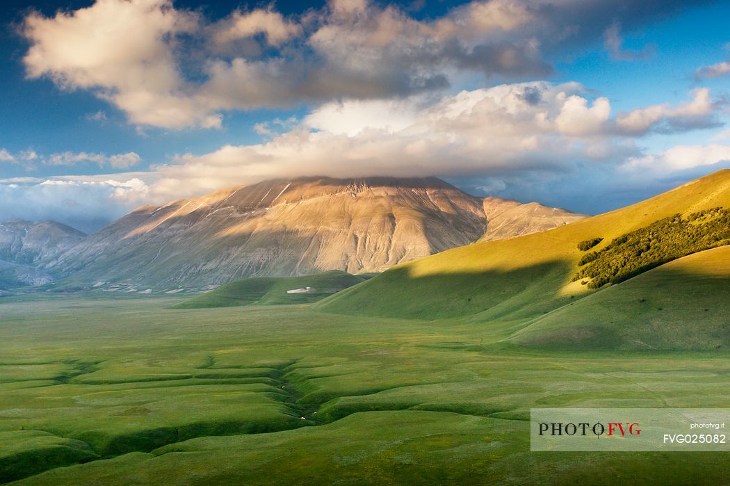 Last lights on Piano Grande Plateau with visible the karst Fosso dei Mergani and in the background Vettore Mount and its fault, Sibillini National Park, Italy