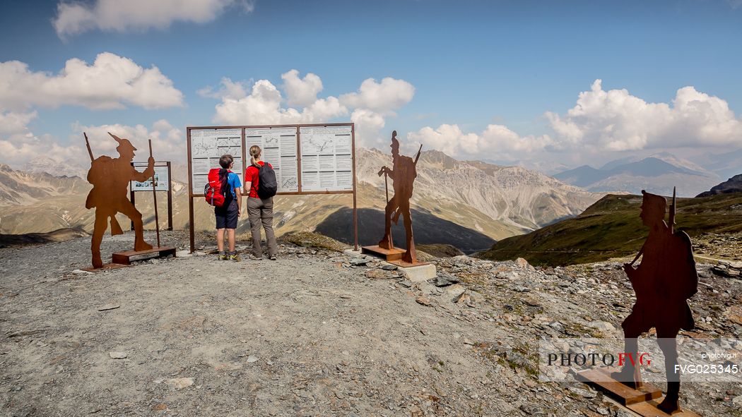 Hikers at Garibaldi peak or Dreisprachenspitze, in the background the swiss alps, Stelvio pass, Stelvio national park, Italy