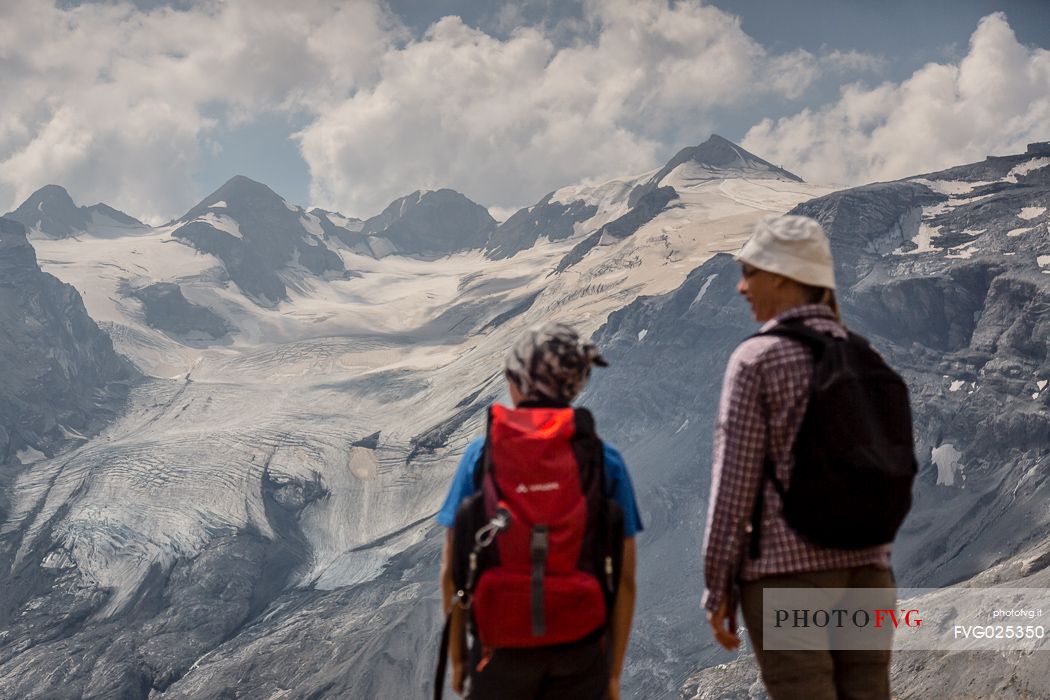 Hikers near Passo dello Stelvio pass and in the background the Stelvio glacier, Passo dello Stelvio national park, Italy