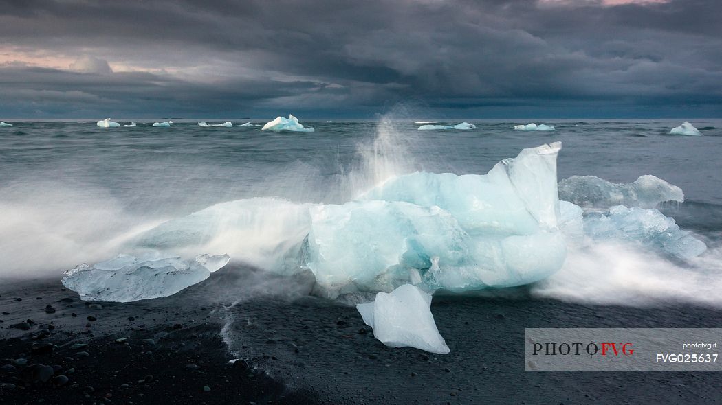 Blue iceberg on black volcanic beach, Jokulsarlon lagoon, Iceland