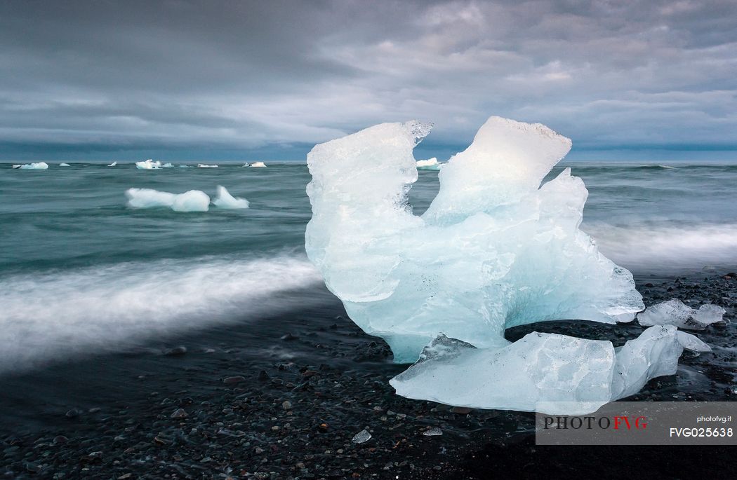 Blue iceberg on black volcanic beach, Jokulsarlon lagoon, Iceland