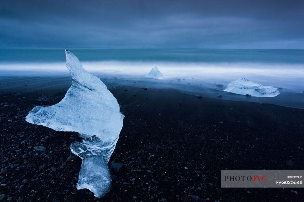 Blue iceberg on black volcanic beach, Jokulsarlon lagoon, Iceland