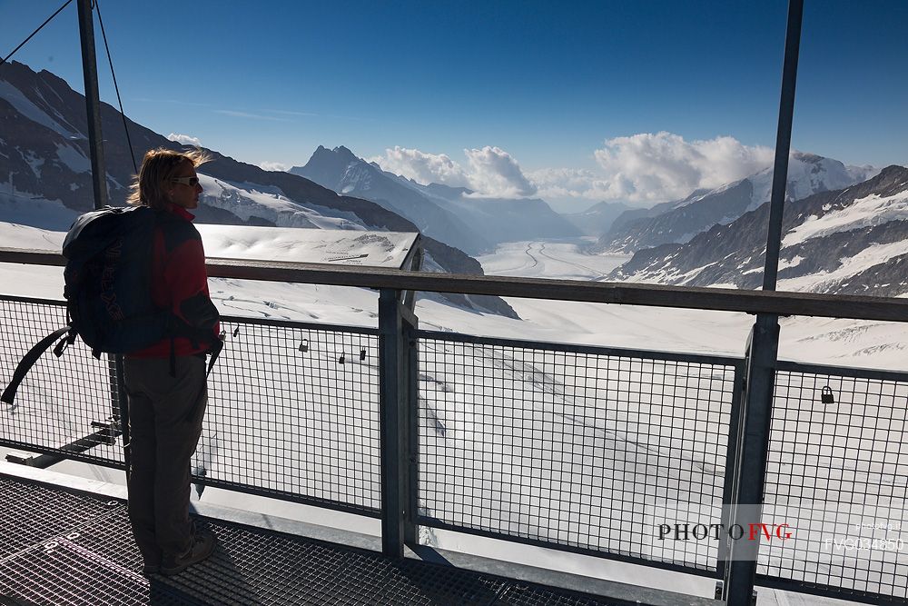 Tourist admiring the Aletsch glacier from the terrace of Sphinx Observatory, Jungfrau Plateau, Top of Europe, Bernese Oberland, Switzerland, Europe