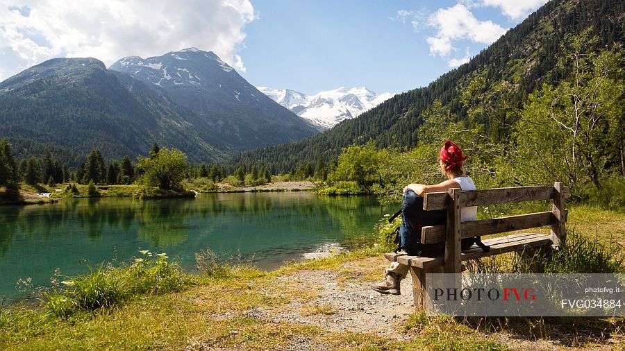 Hiker in the Val Morteratsch valley admiring the glacier and the Bernina mountain range, Pontresina, Engadine, Canton of Grisons, Switzerland, Europe