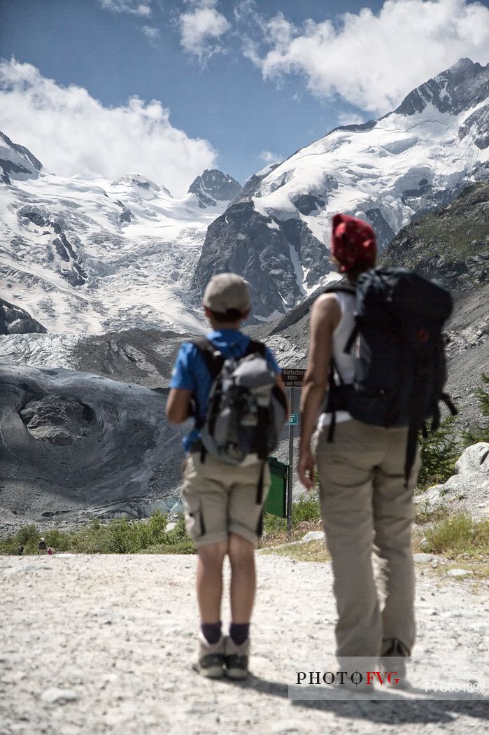 Hiking in Val Morteratsch valley, in the backgrond the glacier and the Bernina mountain range, Pontresina, Engadine, Canton of Grisons, Switzerland, Europe