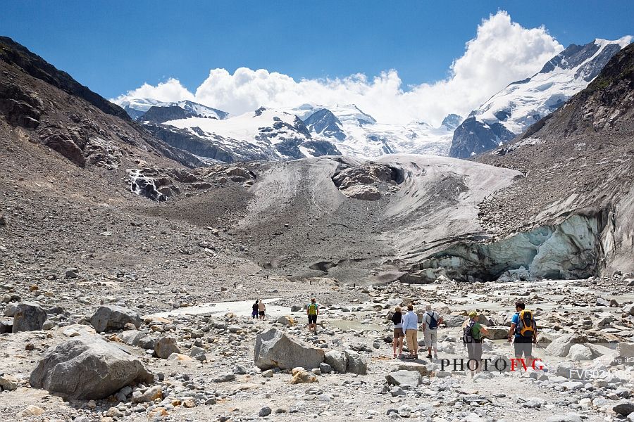 Tourists admiring the Morteratsch Glacier in Val Morteratsh with Bernina mountain group in the background, Pontresina, Engadin, Grisons, Switzerland, Europe
 