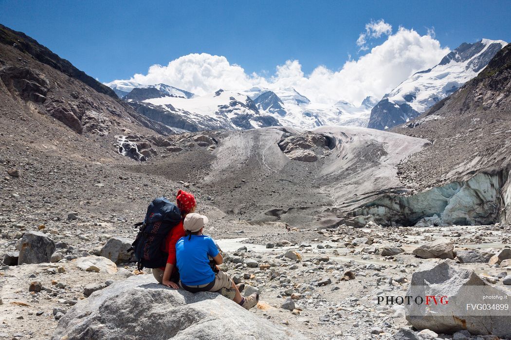 Hikers in Val Morteratsch valley, in the backgrond the glacier and the Bernina mountain range, Pontresina, Engadine, Canton of Grisons, Switzerland, Europe