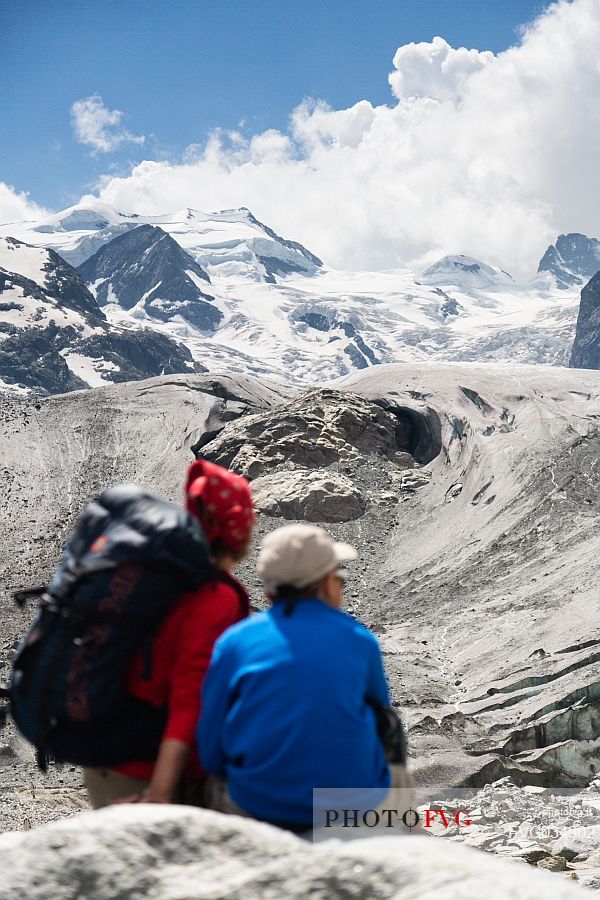 Hikers in Val Morteratsch valley, in the backgrond the glacier and the Bernina mountain range, Pontresina, Engadine, Canton of Grisons, Switzerland, Europe