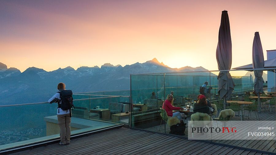 Young woman looking the valley of Saint Moritz at dusk from Romantik Hotel, Muottas Muragl, Samedan, Engadin, Canton of Grisons, Switzerland, Europa