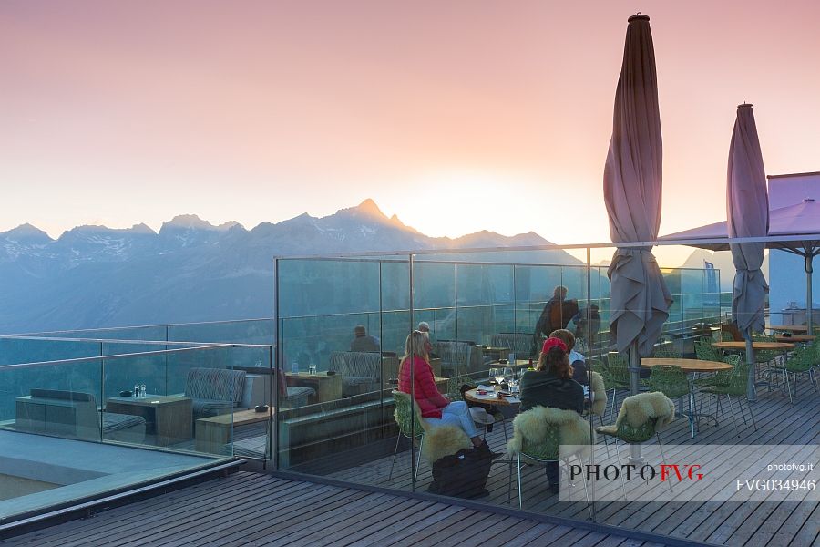 Tourists in the terrace of Romantik Hotel Muottas Muragl at sunset, Muottas Muragl, Samedan, Engadin, Canton of Grisons, Switzerland, Europa