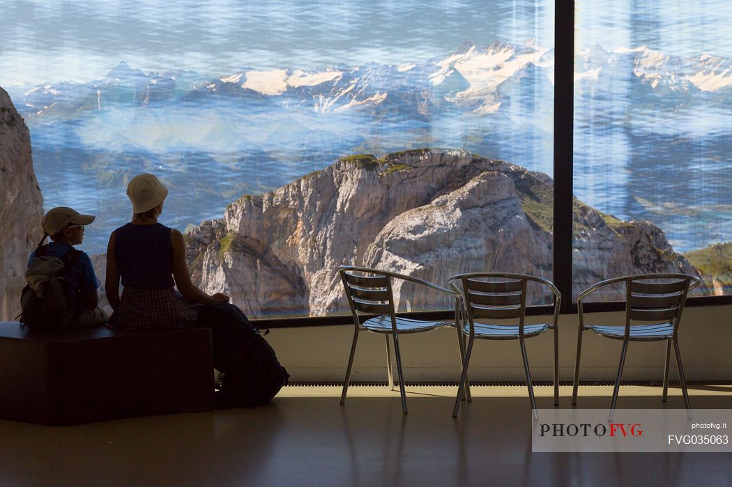 Tourists silhouette looking the panorama of mountains of the Bernese Oberland from summit station of Pilatus Cogwheel Railway , Lucerne, Border Area between the Cantons of Lucerne, Nidwalden and Obwalden, Switzerland, Europe