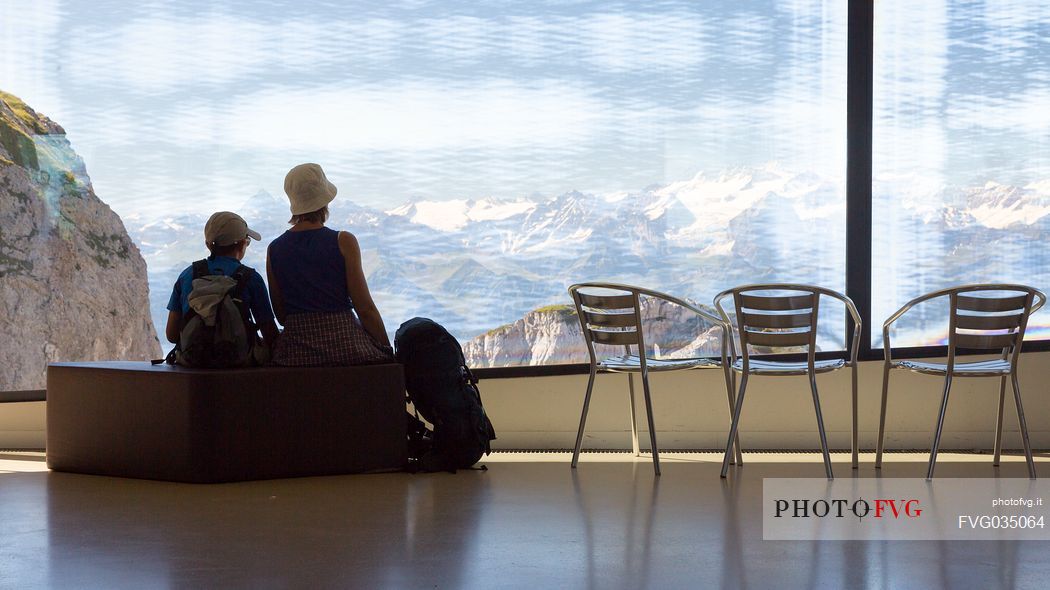 Tourists silhouette looking the panorama of mountains of the Bernese Oberland from summit station of Pilatus Cogwheel Railway , Lucerne, Border Area between the Cantons of Lucerne, Nidwalden and Obwalden, Switzerland, Europe