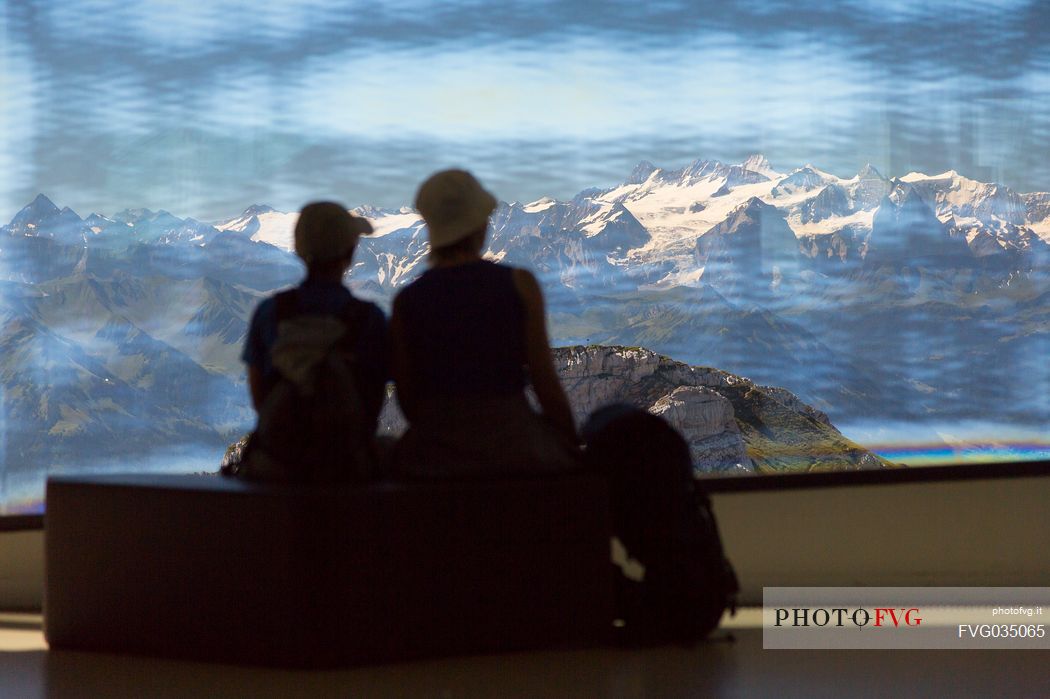 Tourists silhouette looking the panorama of mountains of the Bernese Oberland from summit station of Pilatus Cogwheel Railway , Lucerne, Border Area between the Cantons of Lucerne, Nidwalden and Obwalden, Switzerland, Europe