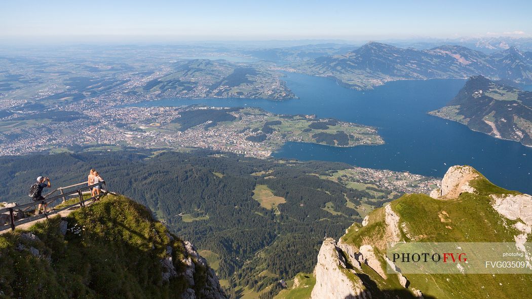 Tourists at the belvedere of Pilatus mount, in the background of the city and the lake of Lucerne, border Area between the Cantons of Lucerne, Nidwalden and Obwalden