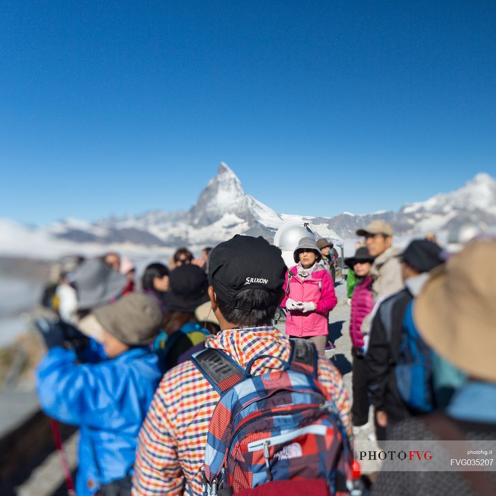 Tourists in the top of Gornergrat admiring  the Matterhorn or Cervino mountain peak, Zermatt, Valis, Switzerland, Europe